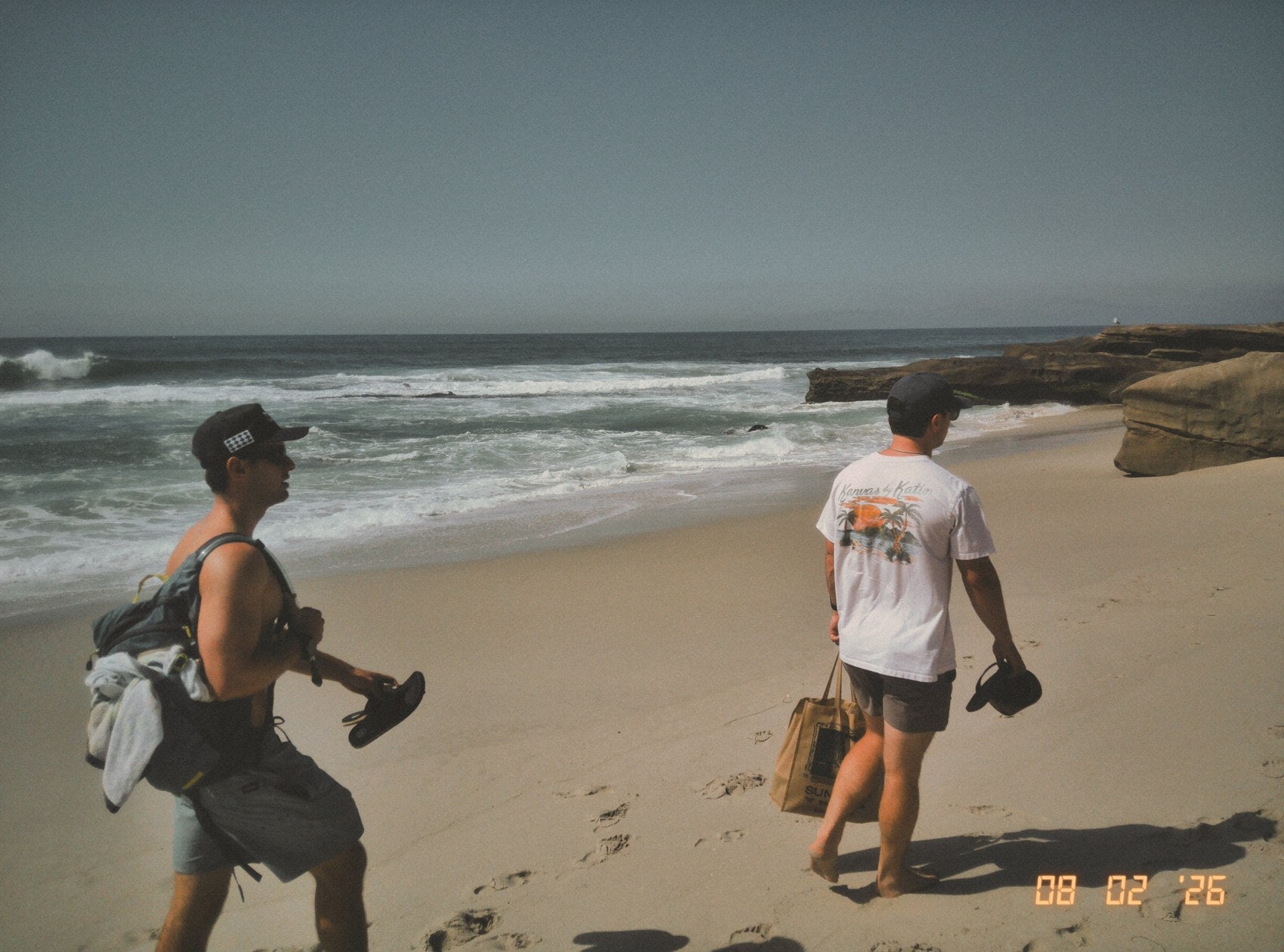 Friends walking together beside the ocean.